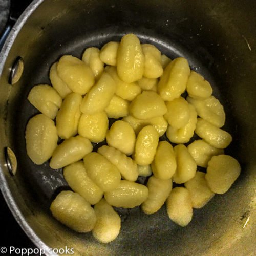 Put a pot of water on at high for the gnocchi and add a some salt. When the water boils add the gnocchi. In about 2 minutes they will float. When they float they are done. Strain them leaving a little water in the pot. Put the gnocchi back in the pot and drizzle with a little extra virgin olive oil. Out the pot on an idle burner or in the oven set on warm or 225° while the chicken progresses.-4-poppopcooks.com